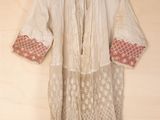 an image of a white shirt hanging on a wall with a wooden hanger