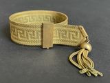 a close up of a belt with a tassel on a table