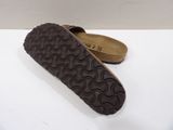 a close up of a pair of brown sandals on a white surface