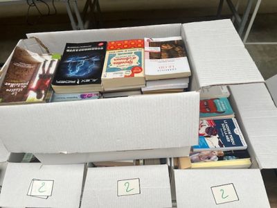 Des cartons de livres sont empilés les uns sur les autres sur une table