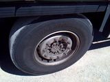 a black truck with a flat tire on the street