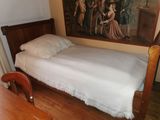 un lit qui se trouve dans une chambre où il y a un tableau accroché au mur