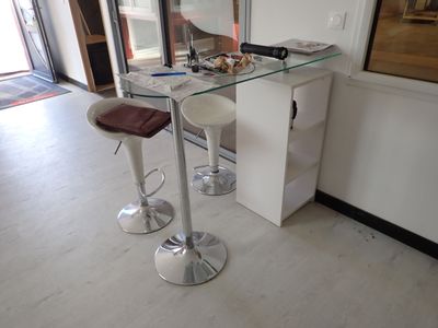 une table en verre avec deux tabourets devant