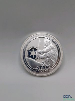 un gros plan d'une pièce d'argent portant le logo de Star Wars