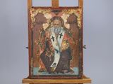 an old painting of a man sitting on a easel with a cross on it