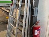 une échelle appuyée contre un mur, à côté d'un extincteur