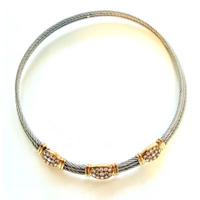 un gros plan d'un bracelet en argent et en or sur fond blanc