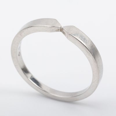 a close up of a silver ring with a curved band