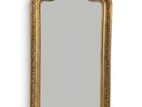 un miroir à cadre doré orné d'un motif décoratif sur le pourtour