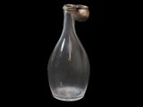 a glass bottle with a metal stopper on a black background