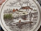 a person holding a plate with a picture of a man in a boat