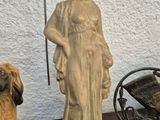 a statue of a woman and two dogs on a table