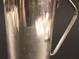 une vieille coupe en argent posée sur une table, devant un fond noir