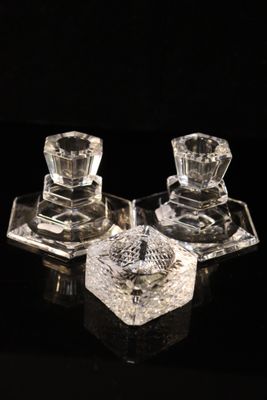 two clear glass candlesticks on a black surface