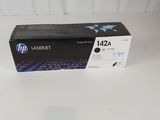 une cartouche de toner HP 124a noire posée sur une surface blanche