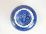 a blue vase with a clock on it sitting on a table