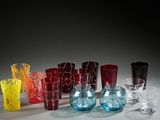 many different colored glass vases and glasses on the table