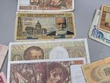 many different bank notes and coins on the table