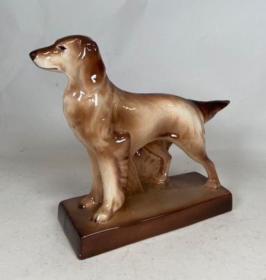 a figurine of a dog that is standing on a base