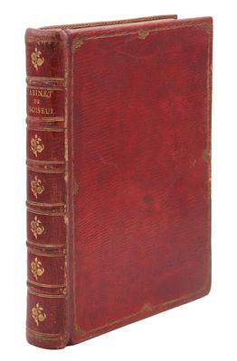 un vieux livre rouge avec des bordures dorées sur la couverture