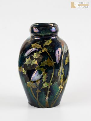 un vase noir orné d'étoiles dorées sur fond blanc