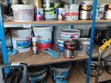 a shelf full of paint and tools in a garage