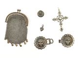 plusieurs objets en métal argenté, notamment un porte-monnaie, une croix et une cotte de mailles