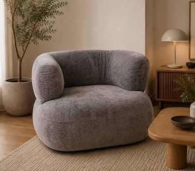 un fauteuil gris dans un salon avec une table basse