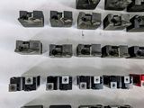 a lot of different types of metal parts on a white surface