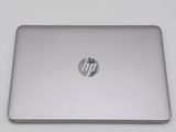 the back of a silver laptop computer sitting on top of a white table