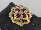 an image of a gold ring with garnets on top of it