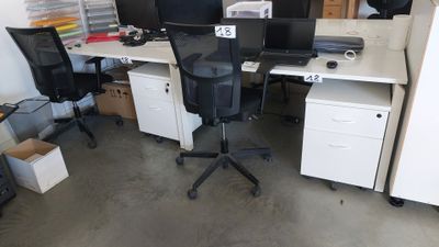 un bureau avec deux ordinateurs et deux chaises dans la pièce