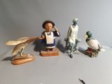 de nombreuses figurines représentant des personnes et des oiseaux posées sur une table