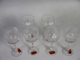 six wine glasses with labels on them sitting on a white surface