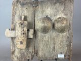 an old wooden door with a metal latch on a stand