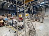une échelle métallique au milieu d'un entrepôt rempli de cartons