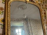 a mirror in the corner of a room with sunflowers on the wall