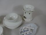 a lot of white dishes and cups on the table
