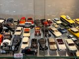 a lot of toy cars on display in a glass case