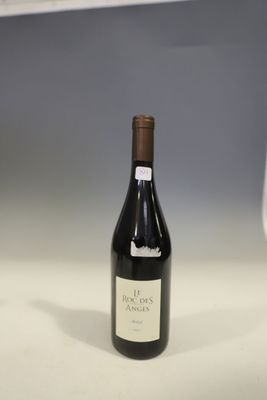 a bottle of wine sitting on a table next to a wine glass