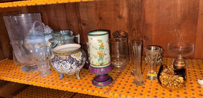 a shelf that has many different glassware on it