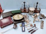 beaucoup d'argenterie sur une table, parmi d'autres objets