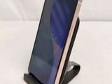 a close up of a cell phone on a stand on a white surface