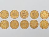 plusieurs pièces d'or sont disposées en ligne sur une surface blanche
