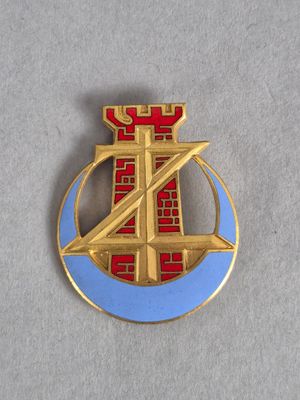 un gros plan d'un insigne rouge et bleu sur une surface grise