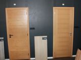 three wooden doors in a room with black walls
