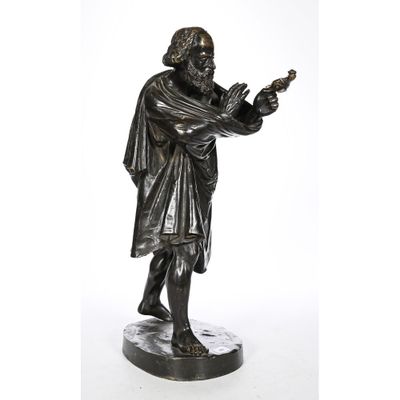 a bronze statue of a man holding a bird in his hand