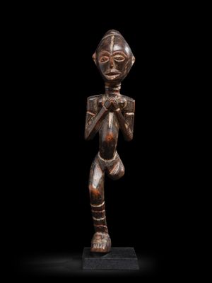 une statue en bronze représentant un homme tenant une épée, sur fond noir