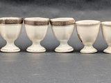 six white wine goblets lined up in a row on a table