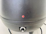 a black pot with a red button on it